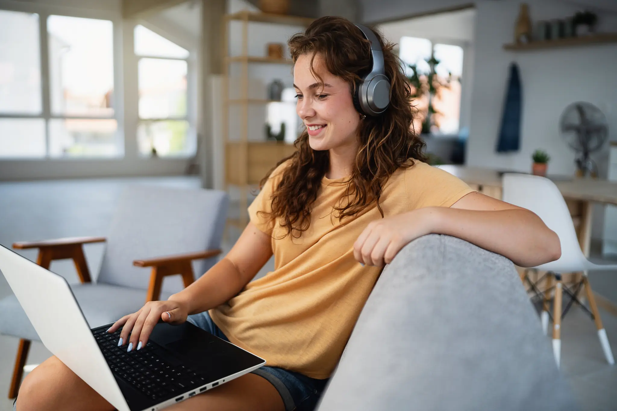 A freelancer working on a laptop in a bright apartment
